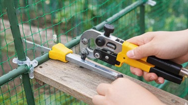 パイプカッターを使って園芸支柱を希望の長さに切断するDIY作業