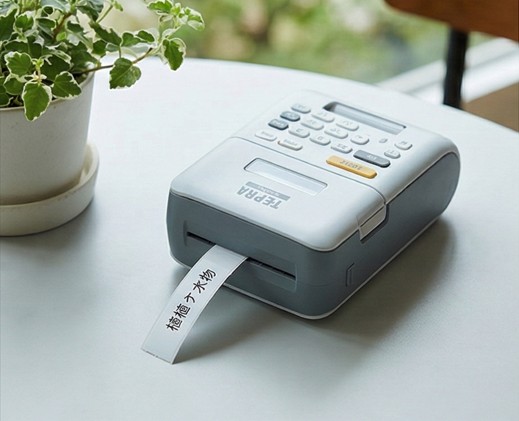 屋外での耐久性が高いラミネートテープを使用して園芸用ラベルを作成しているラベルライターとガーデニング用品