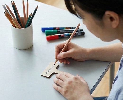 表面をやすり掛けしたプラスチックラベルに2Bの鉛筆で書き込む様子。黒鉛が傷に入り込み定着している拡大写真