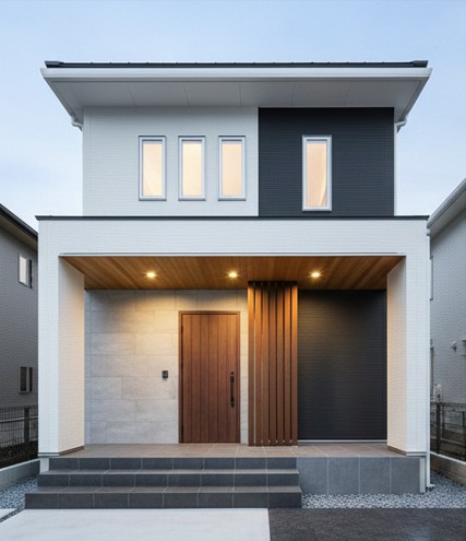 夕暮れ時にライトアップされたおしゃれなシンプルモダンの玄関ポーチと外構デザイン