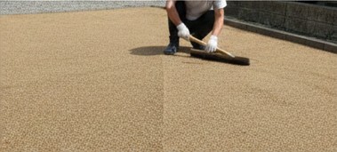 庭の外構DIYで真砂土をトンボで平らにならしている日本人男性の様子