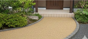 植栽の緑と美しく調和した真砂土仕上げの玄関アプローチ